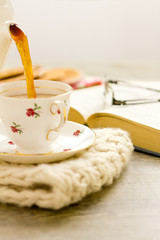 Tea being poured into china teacup vertical