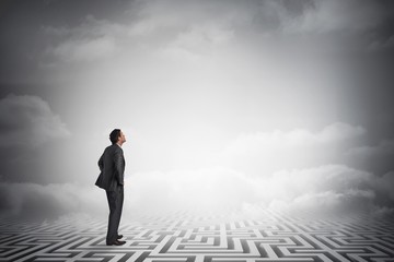 Composite image of smiling businessman with hands on hips