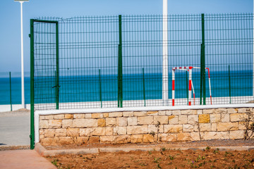 Fenced public sports field against the ocean