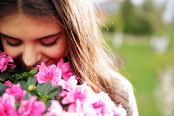Fototapeta premium Young woman smelling pink flowers