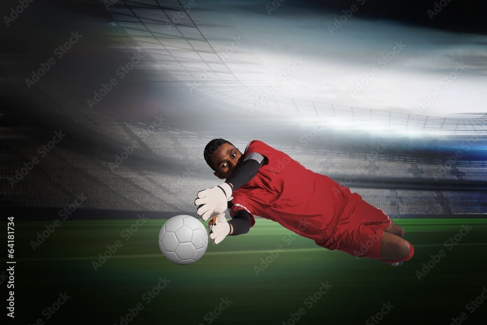 Fototapete composite image of goalkeeper in red making a save