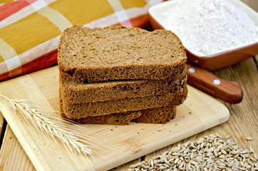 Rye bread with flour and grain on board