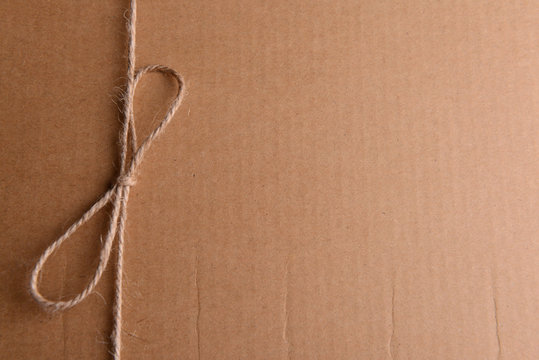 String tied in  bow on brown paper packaging close-up