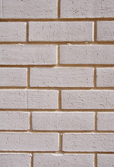 Wall of white bricks with yellow fugue