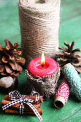 Composition with natural bump, candle, thread, cinnamon sticks