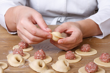 Cook hands sculpt dumplings with minced meat