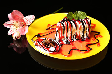 Tasty cake with cream, on black background © Africa Studio