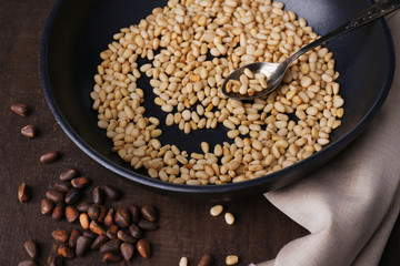 Cedar pine nuts on pan, on wooden table
