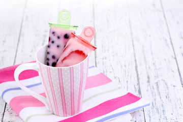 Fruit ice cream in cup on wooden table close-up