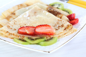 Delicious pancakes with strawberries and chocolate