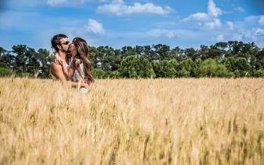 Naklejka na ściany i meble Couple in love kissing in argentinean countryside fields.