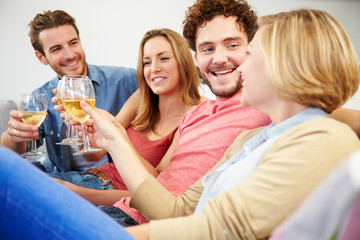 Group Of Friends Enjoying Glass Of Wine At Home