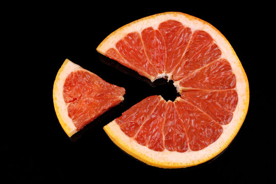 Slice of grapefruit isolated on black