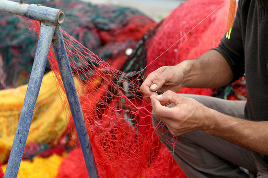 Fisherman Repairs Fishing Net