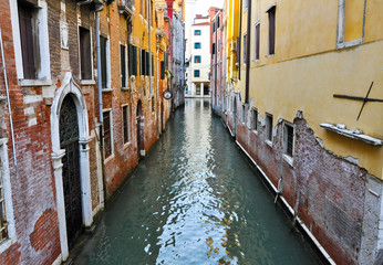 Fototapeta na wymiar Narrow Venetian canal with gondolas in Venice, Italy.