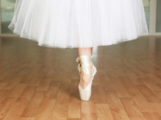 Ballerina legs in pointes in dancing hall © Africa Studio