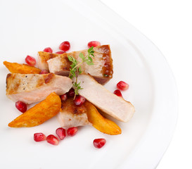Grilled meat  with fried potato pieces and pomegranate seeds
