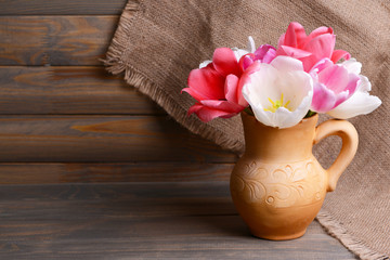 Beautiful tulips in bucket in pitcher