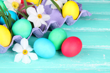 Colorful Easter eggs with grass and flowers in tray