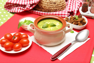 Tasty soup in saucepan on tablecloth, close up