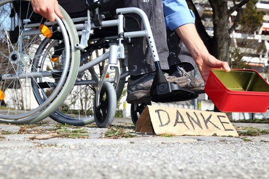 Bedürftiger Rollstuhlfahrer mit DANKE Schild