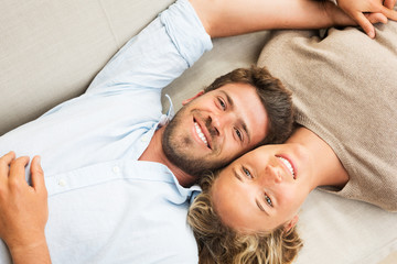 Happy young couple at home on sofa