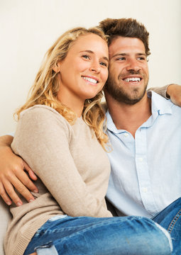 Happy young couple at home on sofa