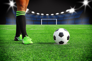 Soccer ball on field in stadium at night 