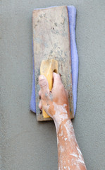 plasterer concrete worker at wall of house construction
