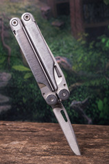 multitool, multi purpose tool with knife stuck on wood