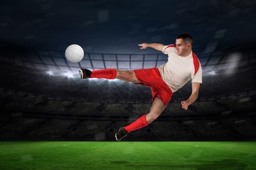 Naklejka premium Composite image of fit football player playing and kicking