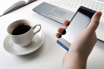 human fingers near the notebook keyboard and smartphone