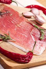 sliced prosciutto on wooden background 