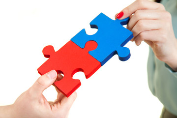 business women assembling jigsaw puzzle and
