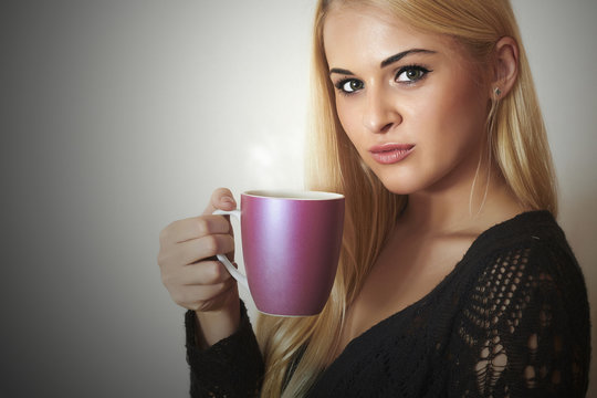 Happy Beautiful woman drinking Coffee.Blond Girl with Cup of tea
