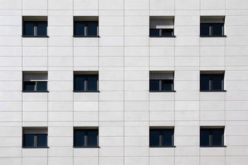 Black windows on white flagstone building facade