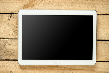 Tablet pc with empty screen and accounting stuff on wooden backg