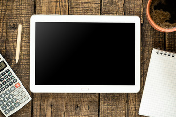 Tablet pc with empty screen and accounting stuff on wooden backg