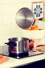 Beautiful caucasian woman standing in kitchen and cooking.