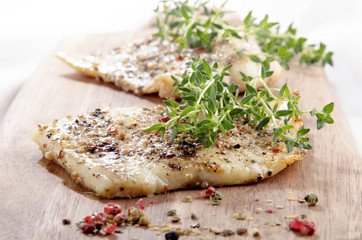 grilled cod on a wooden board