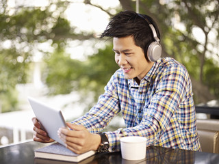 young man using tablet computer in coffee shop