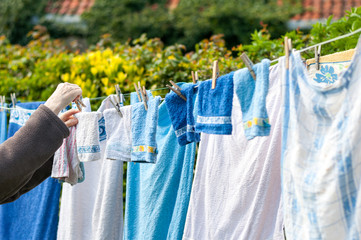 Old woman hanging laundry outdoor