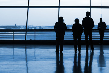 Silhouetts of people waiting at the airport