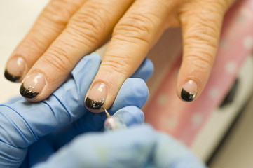 Obraz na płótnie Canvas a nail technician giving a manicure to its customer