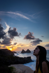 Woman looks at sunset in Fernando de Noronha ,Brazil