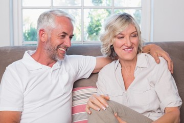 Happy relaxed mature couple sitting on sofa