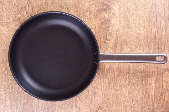 empty frying pan on wooden table