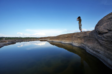 one man stand on stone and water in thailand