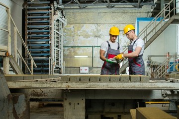 Worker and foreman  performing quality check on a factory