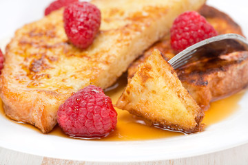 French toast with fresh raspberries and maple syrup, close-up